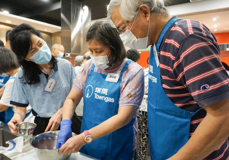 廣輝和煤氣公司義工在旁協助太太參與煮食過程